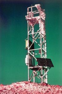 A picture of an antenna, or similar structure, in an icy landscape underneath a turquoise sky.